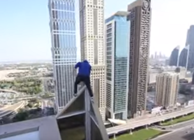 مغامر يتسلق مبنى مرتفع دون أن يستخدم أدوات سلامة