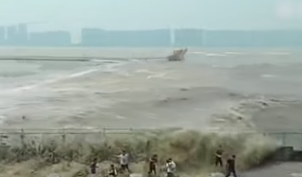 شاهد.. موجة مد عاتية تغمر المارة على ضفة نهر فى الصين